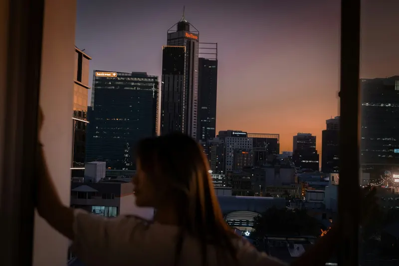 Eine Person schaut aus einem Fenster auf die Stadt